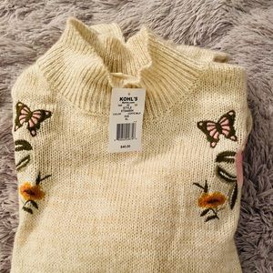 Beige colored sweater with embroidered flowers